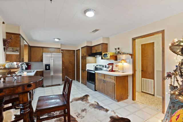 1603 Purple Sage, Horseshoe Bay, TX 78657 - kitchen with appliances with stainless steel finishes, a sink, under cabinet range hood, light flooring, and light countertops