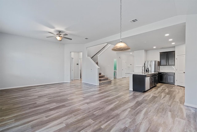 16816 Caperi Dr, Pflugerville, TX 78660 - kitchen with open floor plan, light wood-style floors, a center island with sink, recessed lighting, and ceiling fan