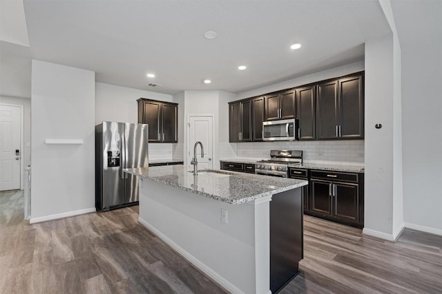16816 Caperi Dr, Pflugerville, TX 78660 - kitchen with appliances with stainless steel finishes, a sink, wood finished floors, baseboards, and recessed lighting