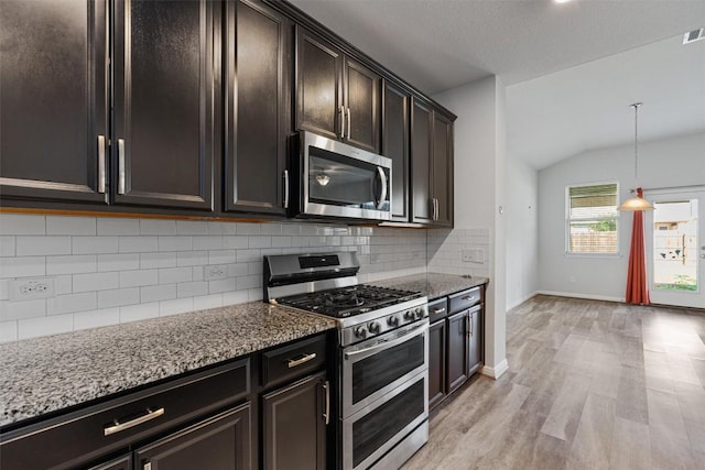 16816 Caperi Dr, Pflugerville, TX 78660 - kitchen with stainless steel appliances, light stone countertops, decorative backsplash, vaulted ceiling, and light wood finished floors