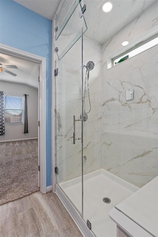 16816 Caperi Dr, Pflugerville, TX 78660 - full bath featuring a marble finish shower, plenty of natural light, a ceiling fan, and wood finished floors