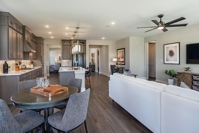 9512 Hamadryas Dr, Austin, TX 78744 - dining area featuring recessed lighting, dark wood-style flooring, baseboards, a ceiling fan, and a chandelier
