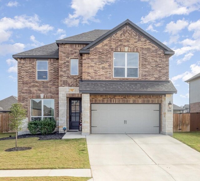 119 Nandina Path, Bastrop, TX 78602 - view of front of home featuring an attached garage, brick siding, driveway, roof with shingles, and stone siding