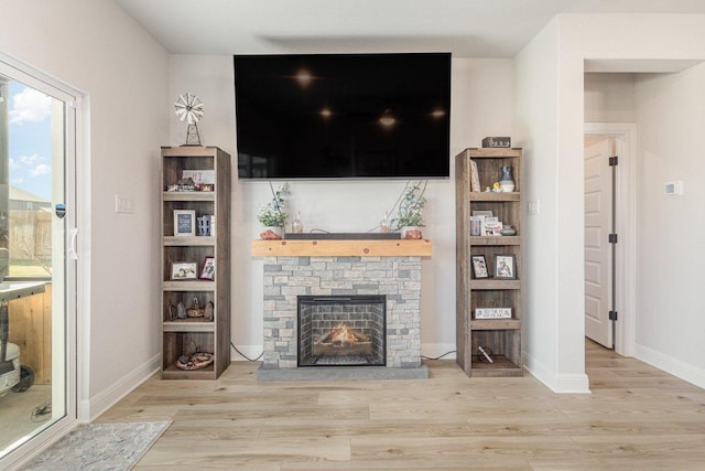 119 Nandina Path, Bastrop, TX 78602 - living area with wood finished floors, a stone fireplace, and baseboards