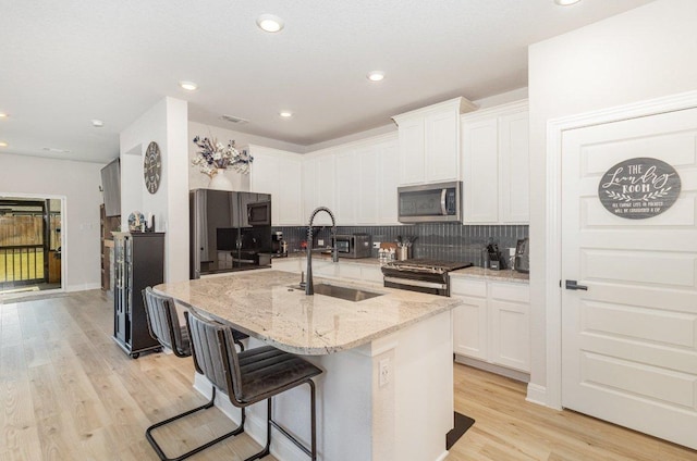 119 Nandina Path, Bastrop, TX 78602 - kitchen featuring stainless steel appliances, a sink, tasteful backsplash, white cabinets, and recessed lighting