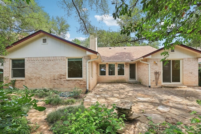 13204 Tamayo Dr, Austin, TX 78729 - rear view of house with a patio area, a chimney, and brick siding