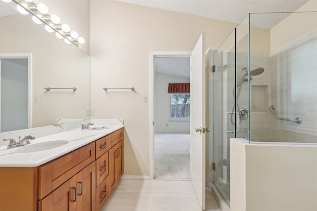 13204 Tamayo Dr, Austin, TX 78729 - bathroom featuring double vanity, a stall shower, tile patterned flooring, and a textured ceiling