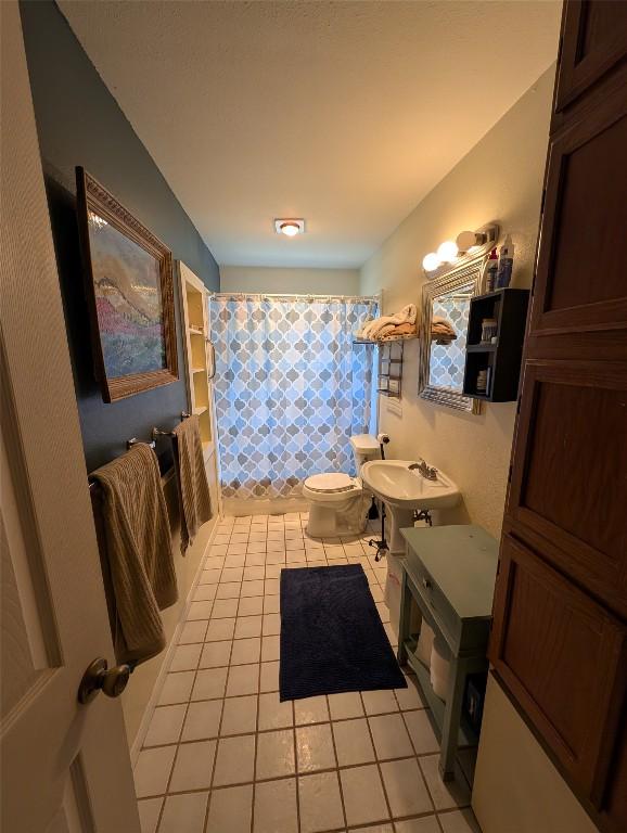 13603 Overland Pass, Bee Cave, TX 78738 - bathroom featuring toilet, tile patterned floors, and curtained shower