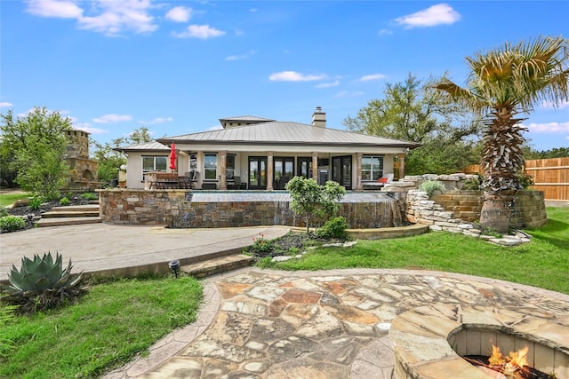 4908 Canyon Ranch Trl, Spicewood, TX 78669 - back of house with a patio, a chimney, and metal roof