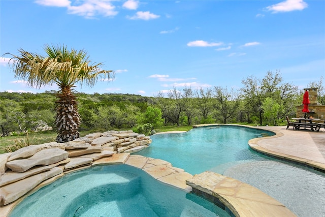 4908 Canyon Ranch Trl, Spicewood, TX 78669 - outdoor pool featuring an in-ground hot tub, a patio area, and a view of trees