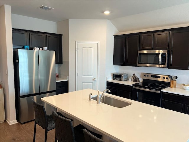 248 Lone Cedar Rd, Marble Falls, TX 78654 - kitchen with appliances with stainless steel finishes, a sink, wood finished floors, light countertops, and a kitchen breakfast bar