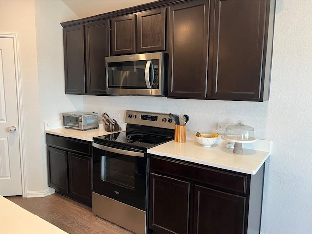 248 Lone Cedar Rd, Marble Falls, TX 78654 - kitchen featuring appliances with stainless steel finishes, light countertops, wood finished floors, and dark brown cabinetry