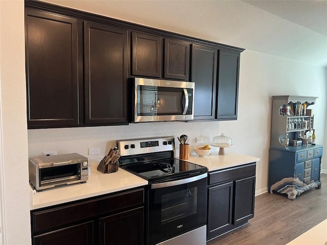 248 Lone Cedar Rd, Marble Falls, TX 78654 - kitchen with stainless steel appliances, wood finished floors, light countertops, baseboards, and dark brown cabinetry