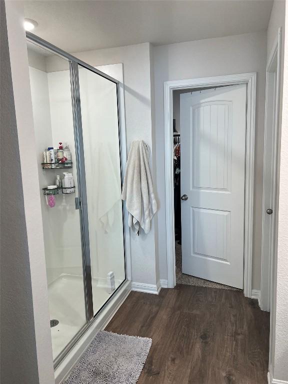248 Lone Cedar Rd, Marble Falls, TX 78654 - full bathroom with a shower stall, wood finished floors, a spacious closet, and baseboards