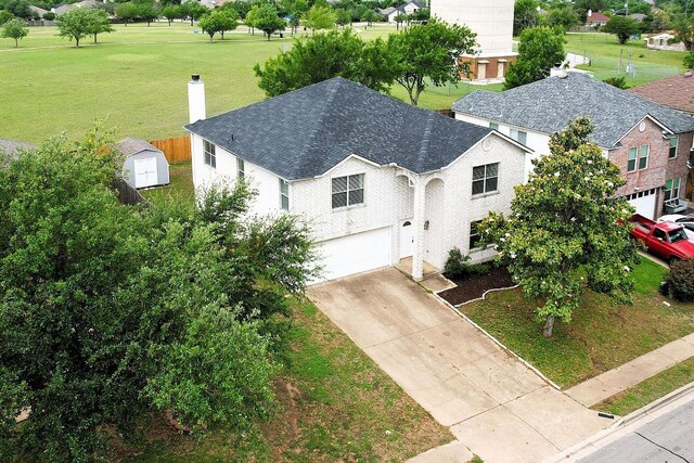 2727 High Point Dr, Round Rock, TX 78664 - view of front facade featuring a chimney, a garage, driveway, a shed, and a front lawn