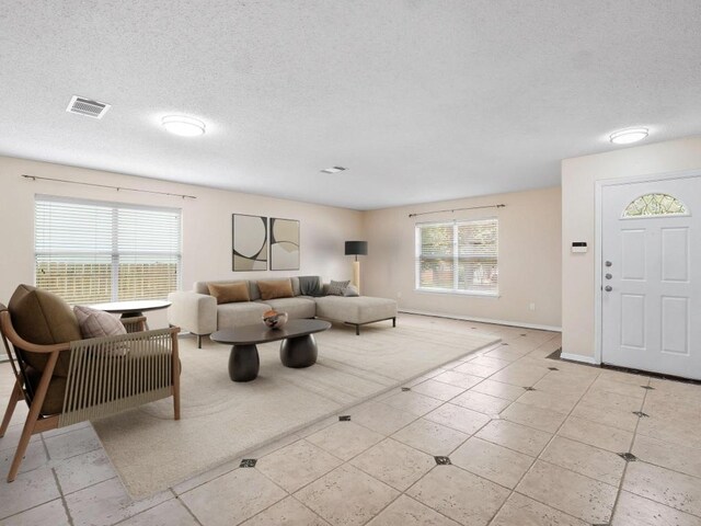 2727 High Point Dr, Round Rock, TX 78664 - living area featuring a textured ceiling, baseboards, and light tile patterned floors