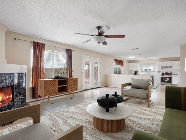 2727 High Point Dr, Round Rock, TX 78664 - living area with light tile patterned floors, healthy amount of natural light, a textured ceiling, and a premium fireplace