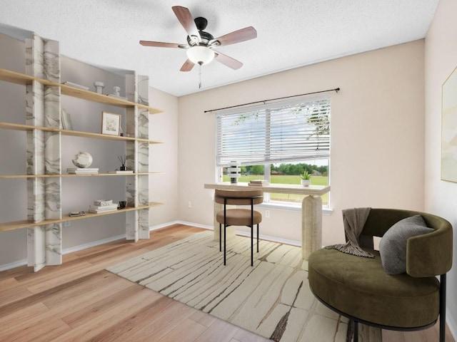 2727 High Point Dr, Round Rock, TX 78664 - living area with wood finished floors, ceiling fan, baseboards, and a textured ceiling
