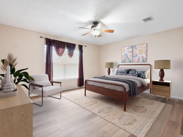 2727 High Point Dr, Round Rock, TX 78664 - bedroom featuring light wood finished floors, a textured ceiling, and ceiling fan