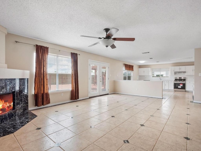 2727 High Point Dr, Round Rock, TX 78664 - unfurnished living room with healthy amount of natural light, a textured ceiling, a fireplace, light tile patterned floors, and ceiling fan