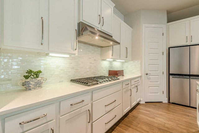 305 Dashing Sycamore St, San Marcos, TX 78666 - kitchen with stainless steel appliances, under cabinet range hood, white cabinetry, light countertops, and light wood-style floors