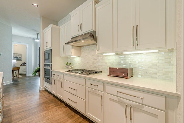 305 Dashing Sycamore St, San Marcos, TX 78666 - kitchen with stainless steel appliances, under cabinet range hood, white cabinets, and decorative backsplash