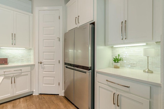 305 Dashing Sycamore St, San Marcos, TX 78666 - kitchen featuring freestanding refrigerator, white cabinetry, decorative backsplash, and light countertops