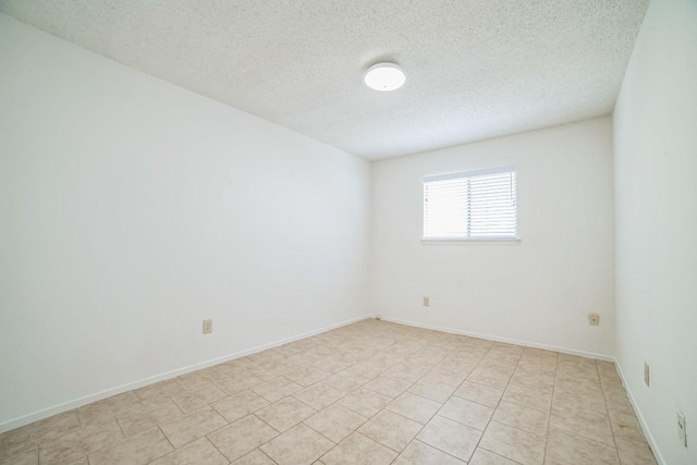 409 Mountain Laurel Dr, Cedar Park, TX 78613 - empty room featuring a textured ceiling, light tile patterned flooring, and baseboards