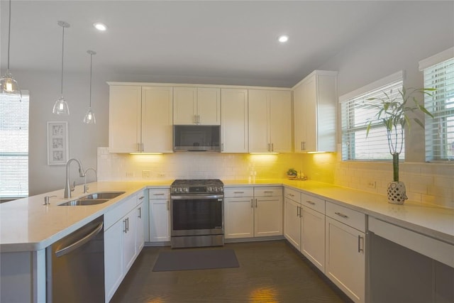2207 Land Grant Way, Round Rock, TX 78664 - kitchen featuring appliances with stainless steel finishes, a peninsula, light countertops, tasteful backsplash, and recessed lighting