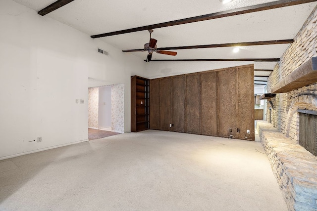 8400 Shenandoah Dr, Austin, TX 78753 - unfurnished living room with beam ceiling, ceiling fan, a stone fireplace, carpet floors, and high vaulted ceiling