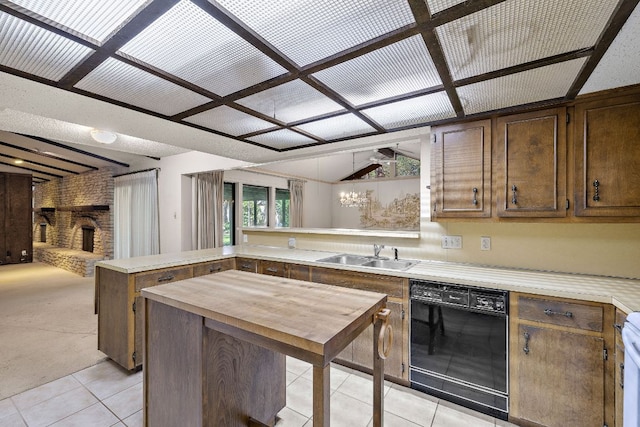 8400 Shenandoah Dr, Austin, TX 78753 - kitchen with black dishwasher, a sink, a fireplace, a peninsula, and light tile patterned flooring