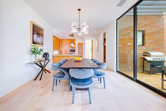 1601 Woodlawn Blvd, Austin, TX 78703 - dining area with light wood finished floors, a chandelier, and baseboards