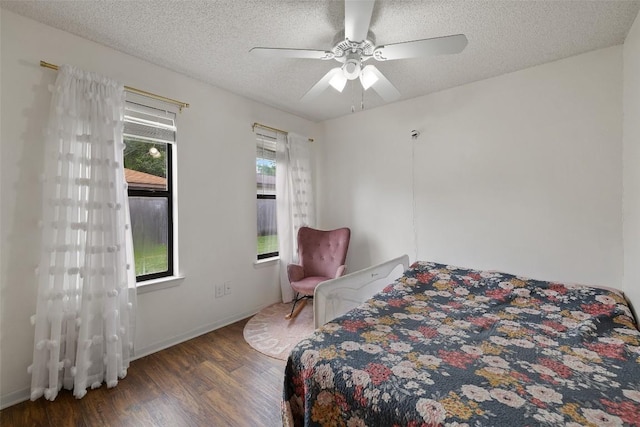 506 S Main St, Thrall, TX 76578 - bedroom with wood finished floors, a textured ceiling, a ceiling fan, and baseboards