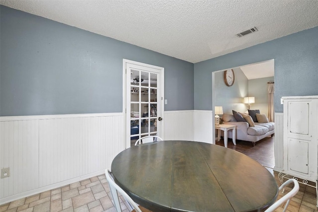 506 S Main St, Thrall, TX 76578 - dining space with a wainscoted wall and a textured ceiling