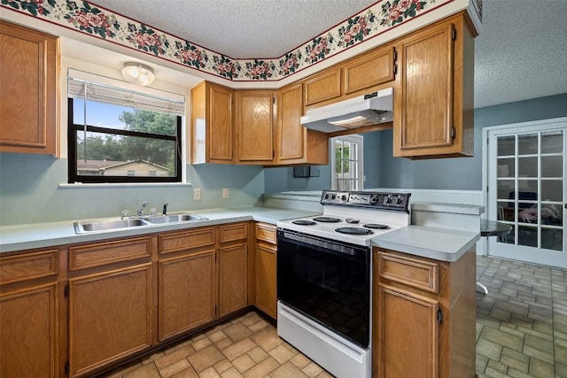 506 S Main St, Thrall, TX 76578 - kitchen with electric range oven, under cabinet range hood, a sink, a textured ceiling, and light countertops