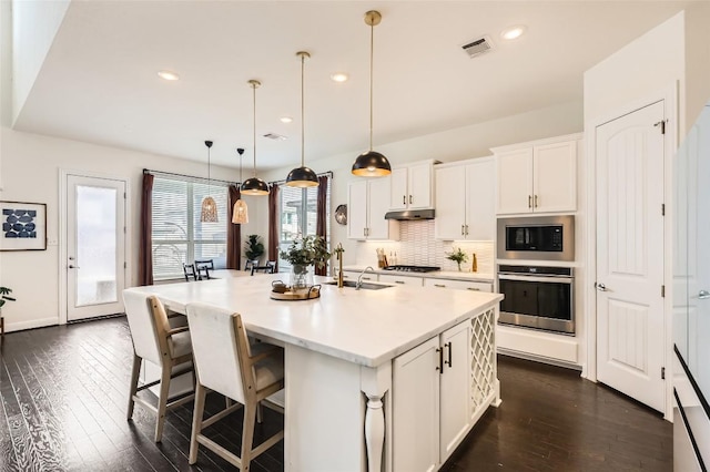 4116 Brean Down Rd, Pflugerville, TX 78660 - kitchen featuring stainless steel oven, built in microwave, a sink, backsplash, and dark wood-style floors