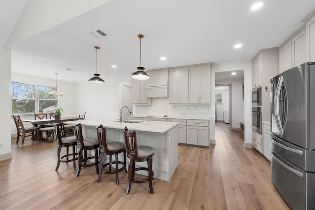 332 Claremont Dr, Belton, TX 76513 - kitchen featuring appliances with stainless steel finishes, a sink, backsplash, light countertops, and light wood finished floors