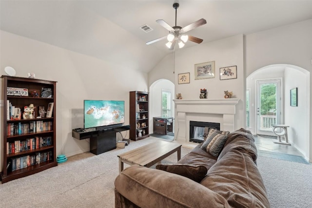 722 Tom Kite Dr, Round Rock, TX 78664 - living room featuring arched walkways, carpet, ceiling fan, a glass covered fireplace, and baseboards