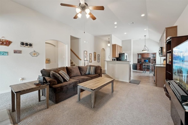722 Tom Kite Dr, Round Rock, TX 78664 - living area with light carpet, arched walkways, ceiling fan, stairs, and high vaulted ceiling
