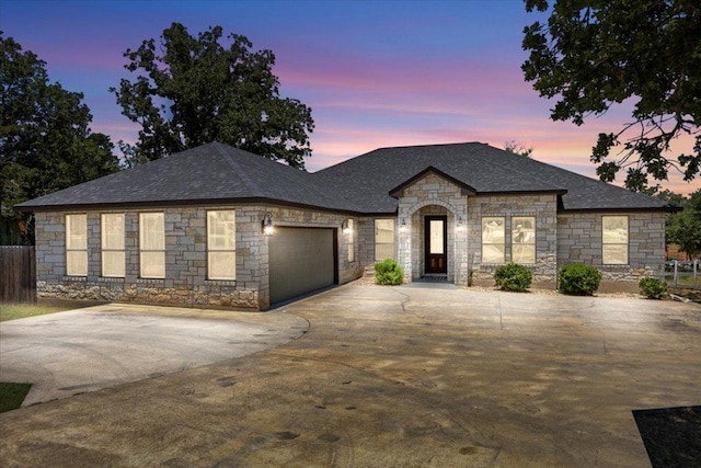 127 Medlar Dr, Cedar Creek, TX 78612 - french country home with stone siding, a garage, driveway, and roof with shingles