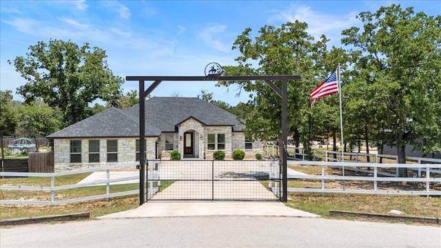 127 Medlar Dr, Cedar Creek, TX 78612 - view of front of home featuring stone siding, a fenced front yard, and a gate
