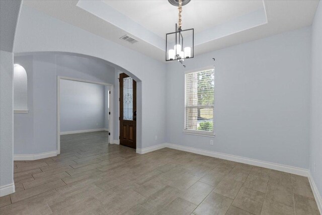 127 Medlar Dr, Cedar Creek, TX 78612 - unfurnished room featuring arched walkways, a chandelier, baseboards, and a raised ceiling