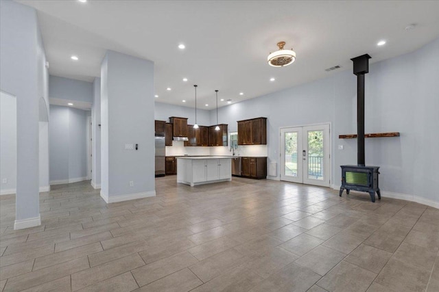 127 Medlar Dr, Cedar Creek, TX 78612 - kitchen featuring open floor plan, freestanding refrigerator, light countertops, a center island, and a wood stove