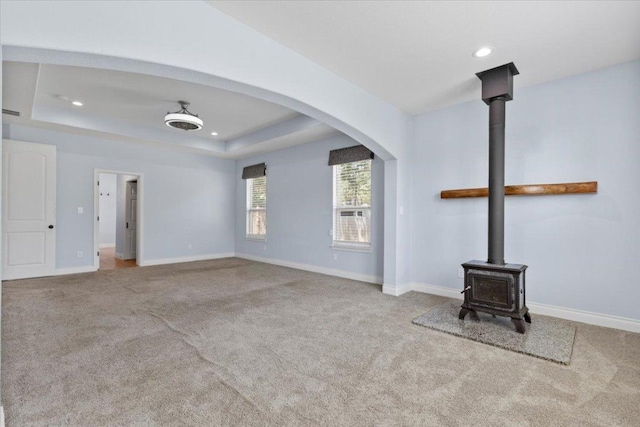 127 Medlar Dr, Cedar Creek, TX 78612 - unfurnished living room with a wood stove, carpet, recessed lighting, baseboards, and a raised ceiling
