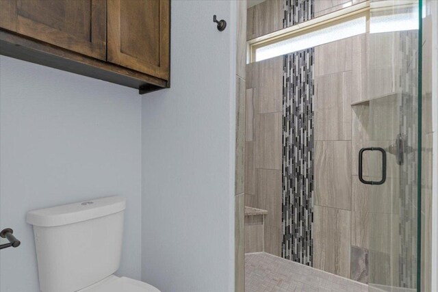 127 Medlar Dr, Cedar Creek, TX 78612 - bathroom featuring a stall shower and toilet