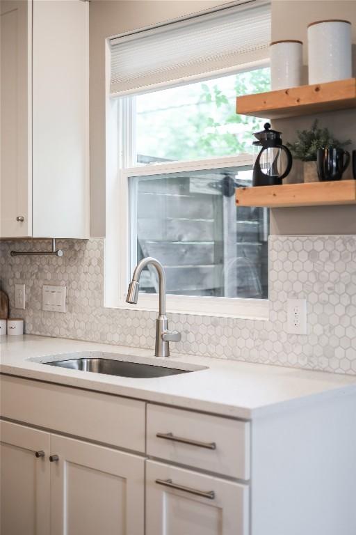 5512 Duval St Unit 2, Austin, TX 78751 - kitchen featuring a sink, backsplash, light countertops, and white cabinets