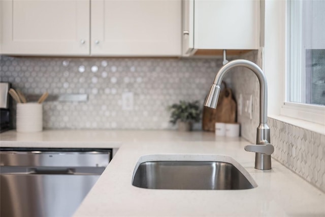 5512 Duval St Unit 2, Austin, TX 78751 - kitchen view of stainless steel dishwasher, decorative backsplash, a sink, and white cabinets