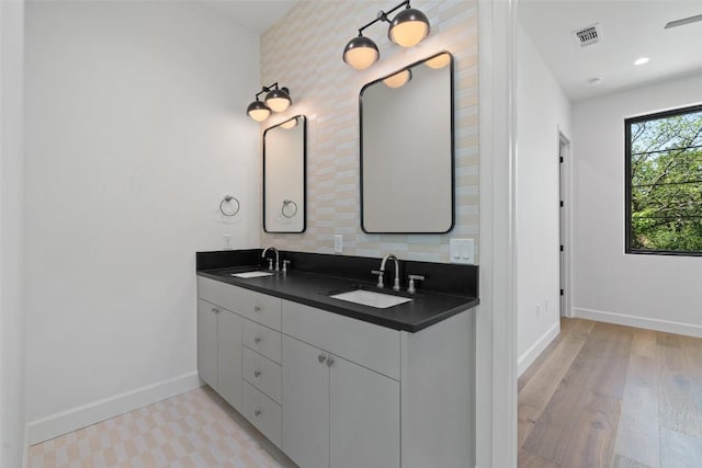 5218 Valley Oak Dr, Austin, TX 78731 - full bathroom featuring double vanity, decorative backsplash, and wood finished floors