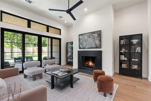 5218 Valley Oak Dr, Austin, TX 78731 - living area featuring ceiling fan, light wood-type flooring, a warm lit fireplace, recessed lighting, and a towering ceiling