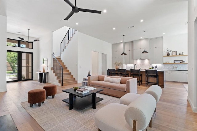 5218 Valley Oak Dr, Austin, TX 78731 - living room with ceiling fan, stairway, a towering ceiling, light wood-style floors, and recessed lighting